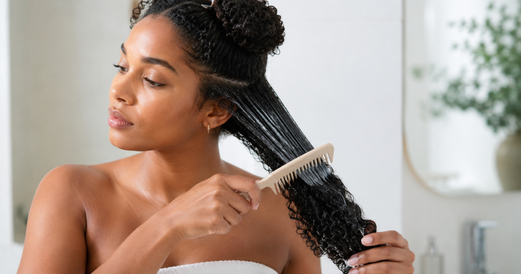 Woman caring for curly hair to reduce frizz in humid weather