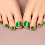 Pedicure with polished toenails on a neutral background