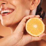 Woman holding a lemon for a vitamin C skincare concept