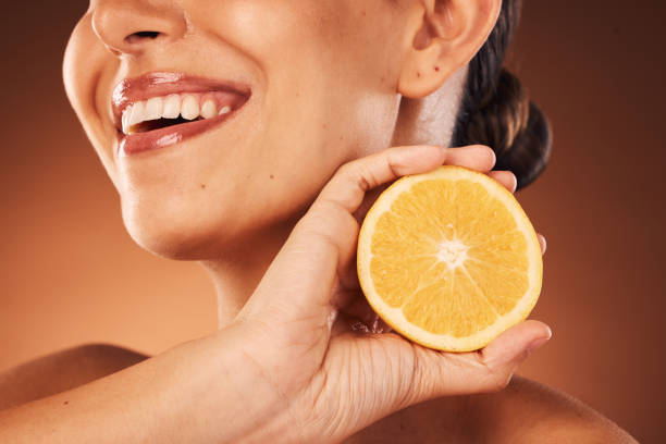 Woman holding a lemon for a vitamin C skincare concept
