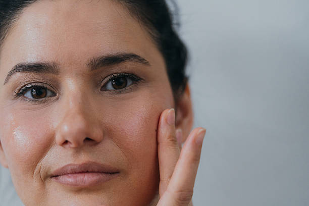 Woman applying facial serum as part of an oily skin routine