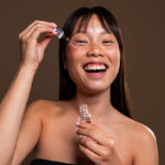 Woman applying facial serum with a dropper